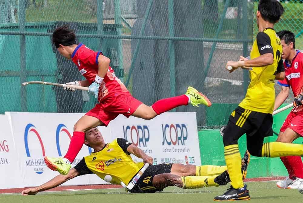 Pemain Malaysia, Harras Osman (dua dari kiri), diasak oleh pemain Jepun, Tanaka Ryuji (kiri), dalam perlawanan penentuan tempat ke-5 dan ke-6 Piala Hoki Sultan Johor (SOJC) di Stadium Hoki Taman Daya, hari ini. - Foto: Bernama