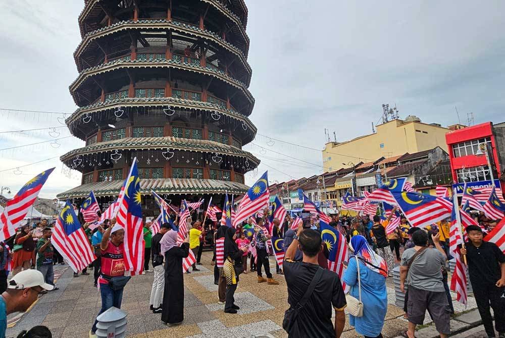 Orang ramai berkumpul di Dataran Menara Condong Teluk Intan menyokong usaha mengibarkan Jalur Gemilang susulan isu pengibaran bendera negara China dalam sambutan Guan Gong Sedunia, Khamis lalu.