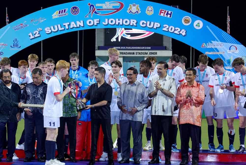 Tunku Abu Bakar Sultan Ibrahim (depan empat, kanan) berkenan menyampaikan piala kemenangan SOJC edisi ke-12 itu kepada pasukan Great Britain selepas muncul Juara Kejohanan Hoki Piala Sultan Johor (SOJC) 2024 selepas menundukkan Australia 3-2, di Stadium Hoki Taman Daya hari ini.  - Foto: Bernama