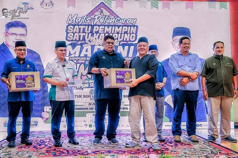 Pemangku Ketua Pegawai Eksekutifnya, Datuk Mohd Nizam Yahya (kiri) mengiringi Ketua Menteri, Datuk Seri Ab Rauf Yusof (tiga, kiri) dan Menteri di Jabatan Perdana Menteri (Hal Ehwal Agama), Datuk Dr Mohd Nai&#039;im Mokhtar (dua, kiri) menyampaikan bantuan bakul makanan kepada salah seorang asnaf pada Majlis Perasmian Peluncuran Satu Pemimpin Satu Kampung (Santuni MADANI) di Kampung Balik Batu, Tanjung Bidara, Alor Gajah, pada Sabtu.