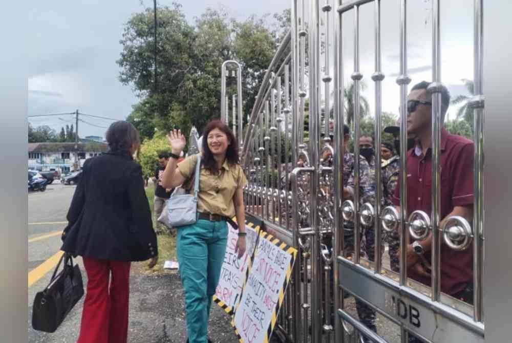 Dua aktivis haiwan berdiri di pintu masuk Majlis Daerah Besut (MDB) bagi menggesa siasatan dilakukan terhadap kematian seekor anjing liar digelar Kopi, baru-baru ini.