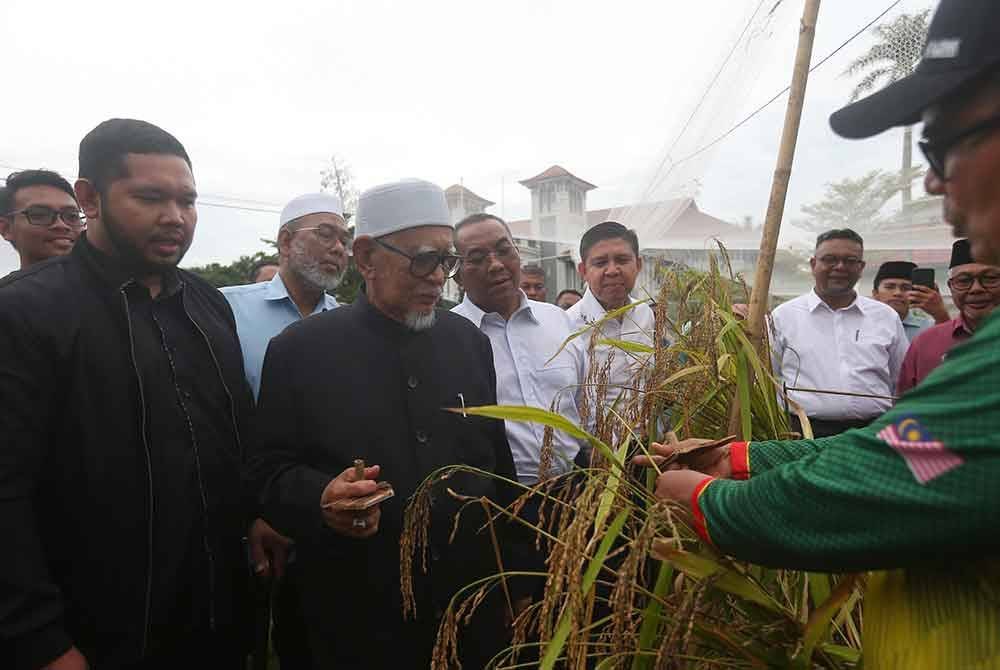 Zakaria menunjukkan padi huma yang dituai kepada Abdul Hadi (dua dari kiri) sambil disaksikan Sanusi (tiga dari kiri).