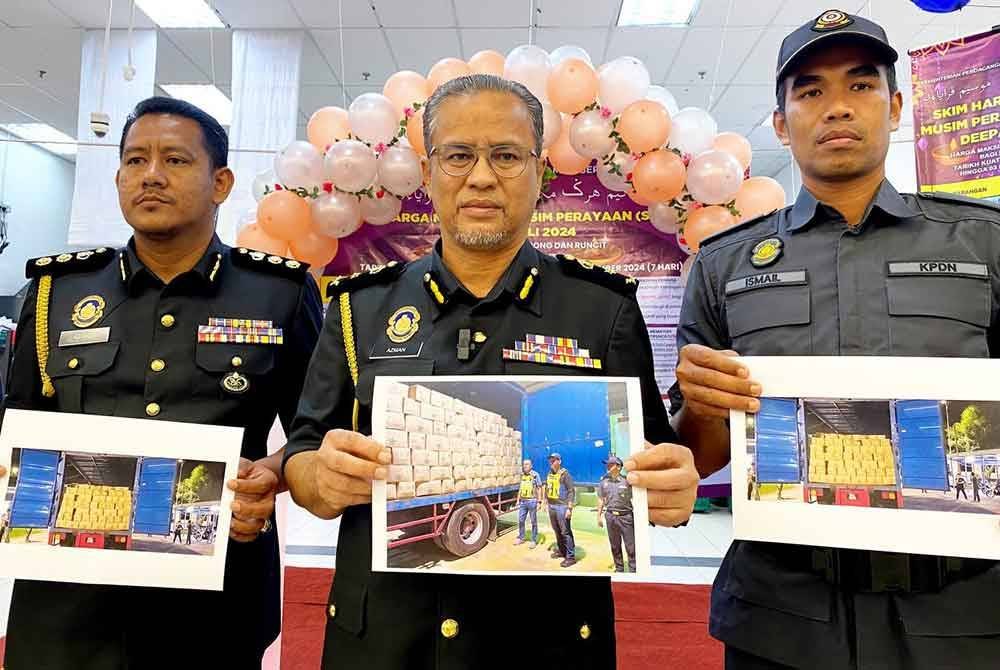 Azman (tengah) menunjukkan minyak masak peket yang berjaya dirampas sebelum diseludup ke negara jiran.