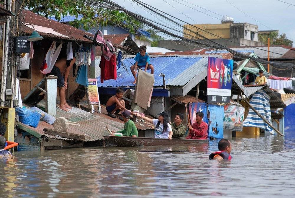 Beberapa mangsa yang terpaksa meninggalkan rumah mereka akibat banjir mula kembali ke rumah masing-masing apabila banjir mulai surut pada Sabtu. Foto AFP