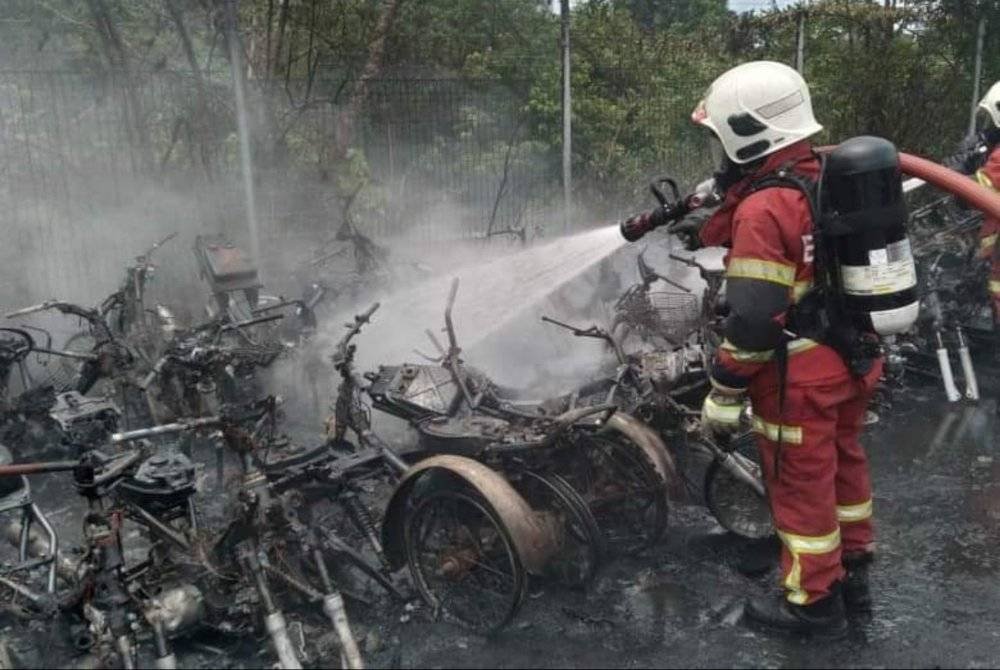 Anggota bomba memadam kebakaran di depoh penyimpanan kenderaan tersadai milik DBKL di Taman Connaught, Kuala Lumpur pada Ahad.