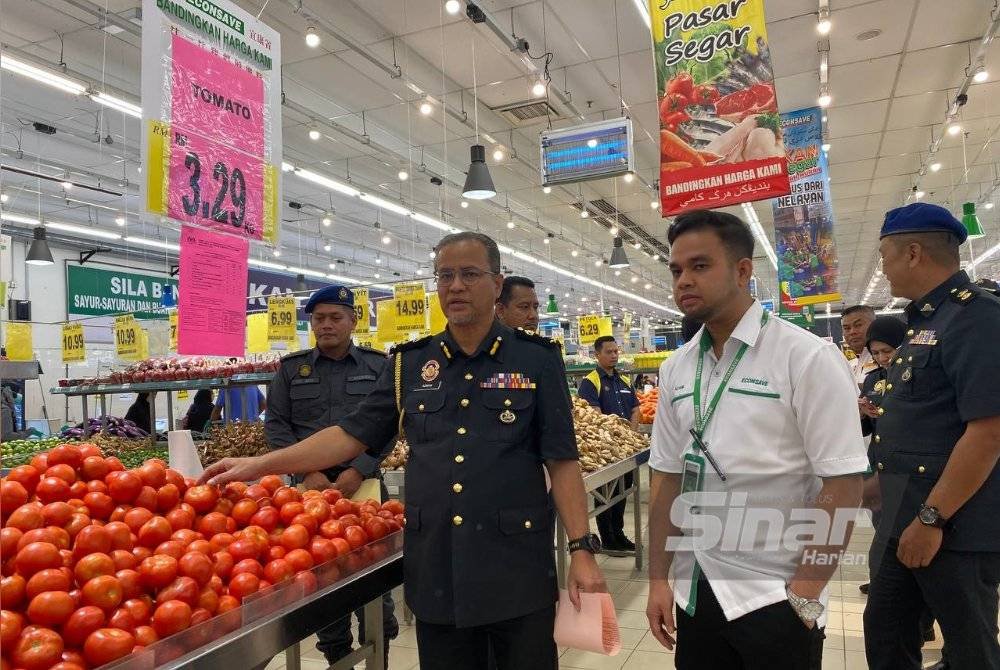 Azman (kiri) semasa melakukan walkabout sempena pelaksanaan SHMMP Deepavali 2024 di Pasaraya Econsave Pasir Puteh pada Isnin.