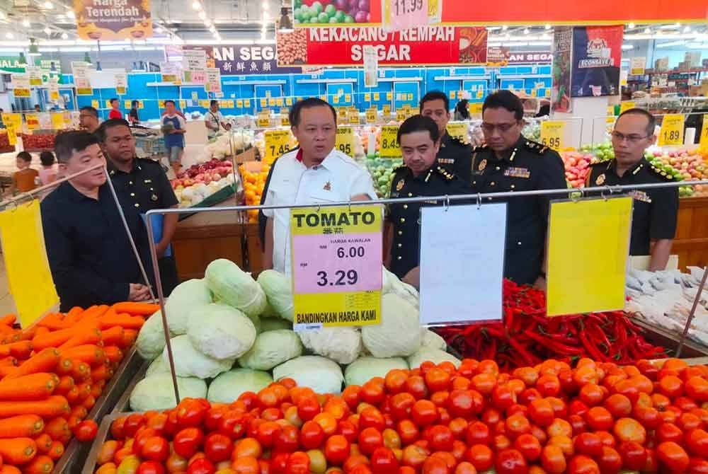 Mohd Zuhairi (tiga, kanan) mengiringi Rizam (tengah) melakukan pemeriksaan pematuhan di Pasaraya Econsave Pandamaran, Klang.