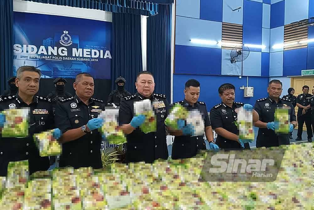 Kok Chin (tiga dari kiri) menunjukkan dadah jenis syabu yang dirampas selepas polis melakukan pemeriksaan di sebuah rumah teres di Bandar Bukit Puchong, Selangor pada Jumaat.