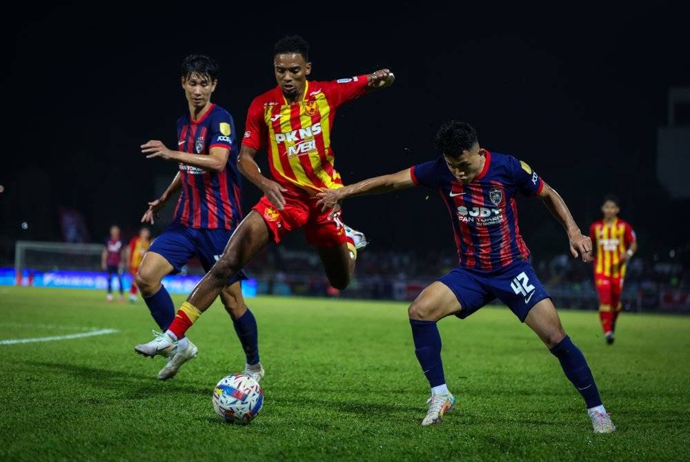 Pemain Selangor FC Alvin Matues Fortes (tengah) diasak Pemain Johor Darul Ta’zim (JDT) Arif Aiman Mohd Hanapi (kanan) pada perlawanan Liga Super 2024-2025 di Stadium Majlis Bandaraya Petaling Jaya, malam tadi. Foto Bernama