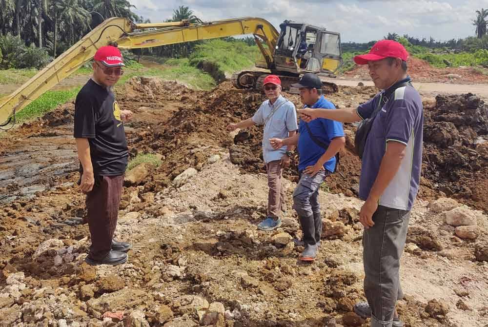 Mohamad Afandy (kiri) bersama penduduk menunjukkan ban runtuh di lembangan Sungai Buloh di sini pada Selasa.