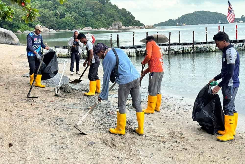 Pekerja Silicon Island Development sedang membersihkan permukaan pantai Pantai Esen yang dipercayai dipenuhi objek dipercayai alga.