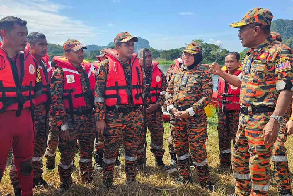 Ahmad Izram (kanan) memberikan arahan kepada pasukan PPDA yang terlibat dalam operasi memindahkan mangsa banjir pada latihan REDEX di Taman Rekreasi Kolam Sungai Pinji di Tanjung Rambutan pada Rabu.