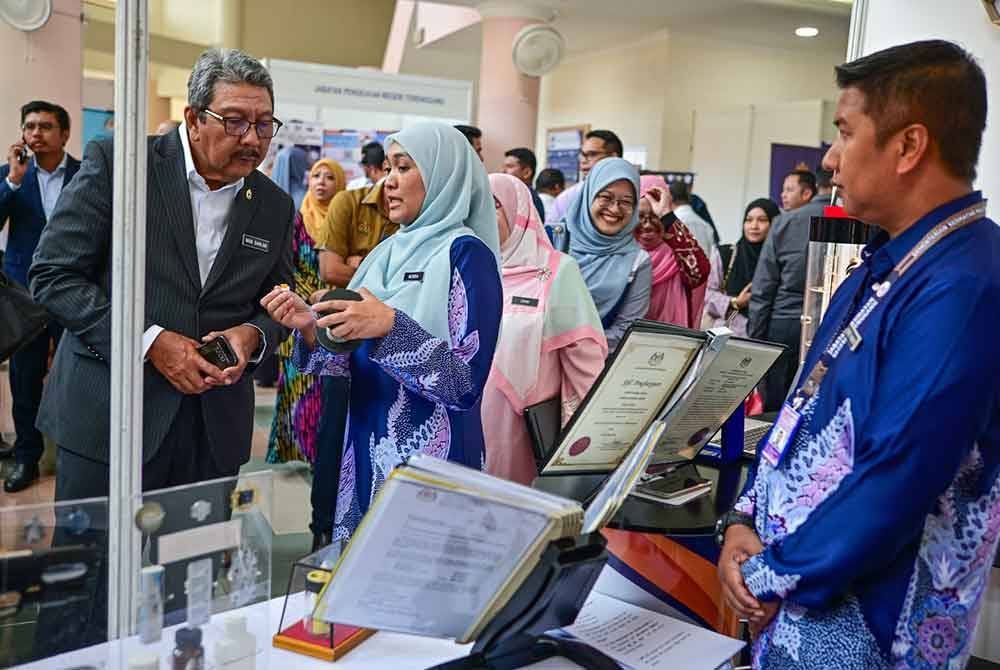 Wan Ahmad Dahlan (kiri) melawat pameran sempena majlis perjumpaan bersama pegawai awam persekutuan negeri Terengganu di Kuala Nerus pada Rabu.