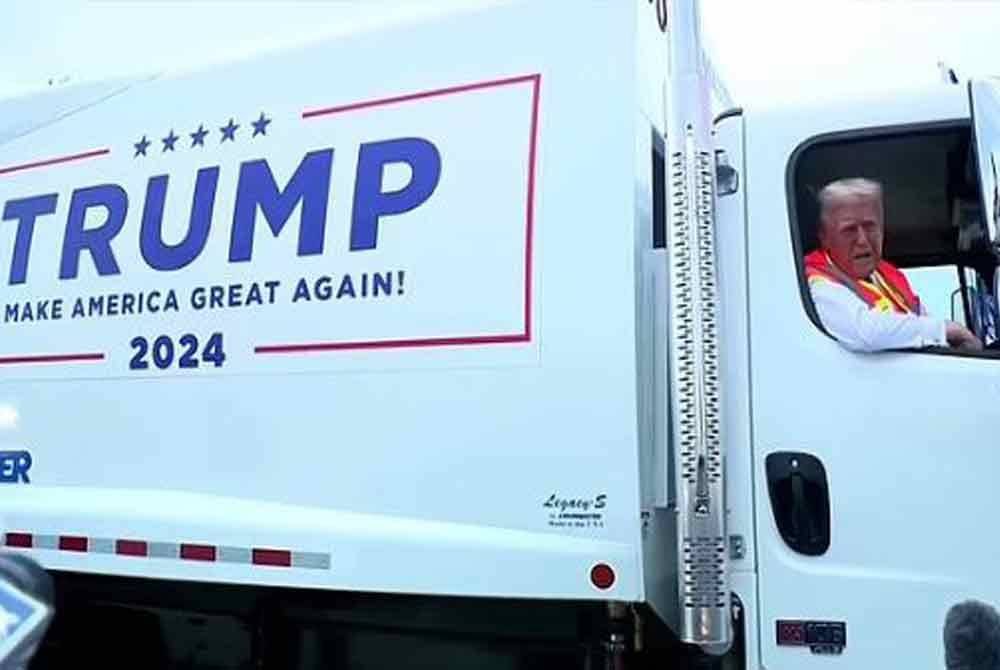 Lori sampah dipandu Trump tertera slogan popular beliau, Make America Great Again. Foto Agensi