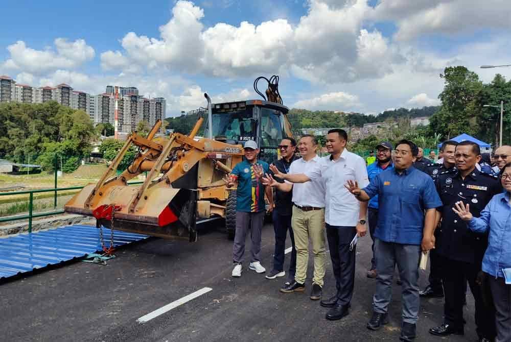 Sze Han (tiga dari kiri) meninjau kawasan tanah runtuh Taman Wawasan yang telah siap dibaiki pulih.