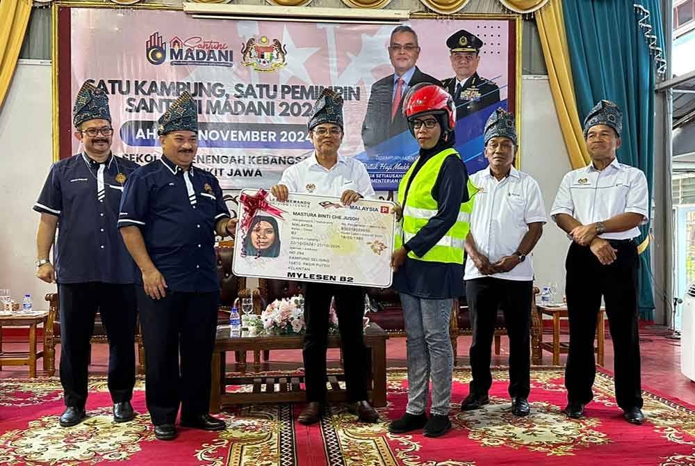 Makhzan (tiga dari kiri) dan Muhammad Kifli (dua dari kiri) menyampaikan lesen kepada penerima di SMK Bukit Jawa di Pasir Puteh.