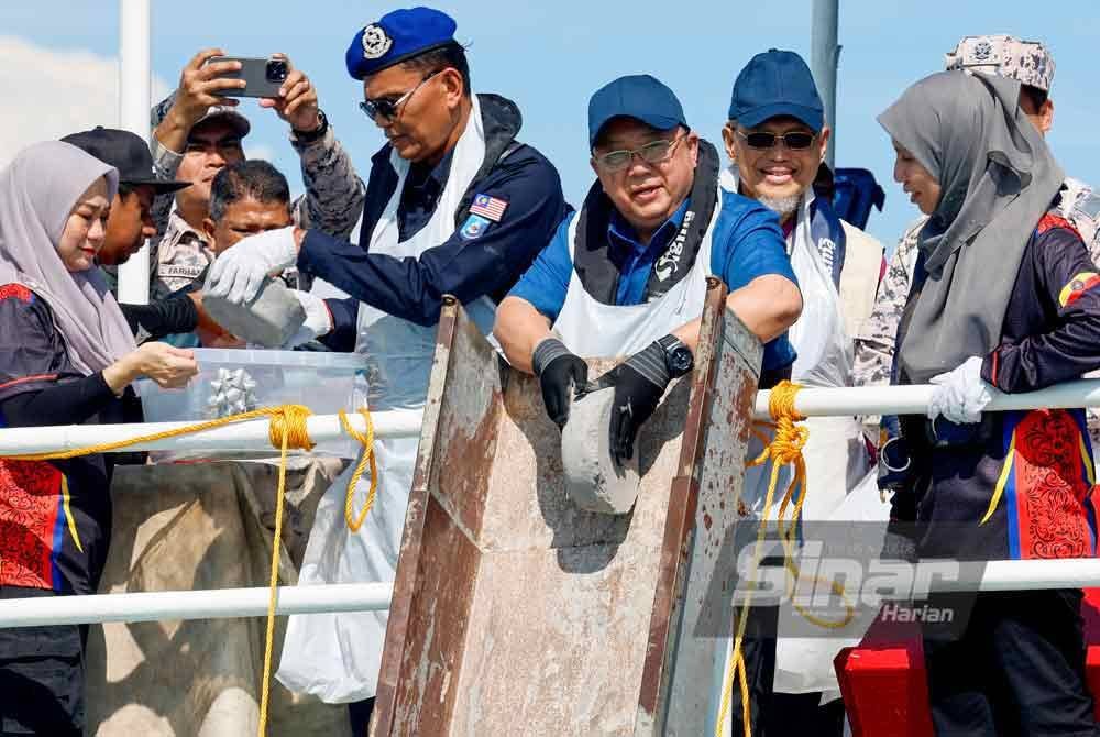 Nik Yusaimi (tiga dari kanan) melepaskan abu Al-Quran ke laut pada Program Pemuliaan (Pelupusan) Abu Al-Quran di bawah Akta Pencetakan Teks Al-Quran 1986 di perairan Pulau Angsa, hari ini. - Foto: Bernama