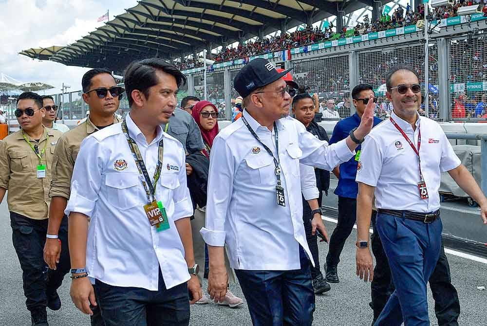 Anwar (dua dari kiri) melambaikan tangan kepada para penonton ketika hadir pada perlumbaan Grand Prix (GP) Motosikal Malaysia 2024 di Litar Antarabangsa Sepang hari ini. Foto Bernama