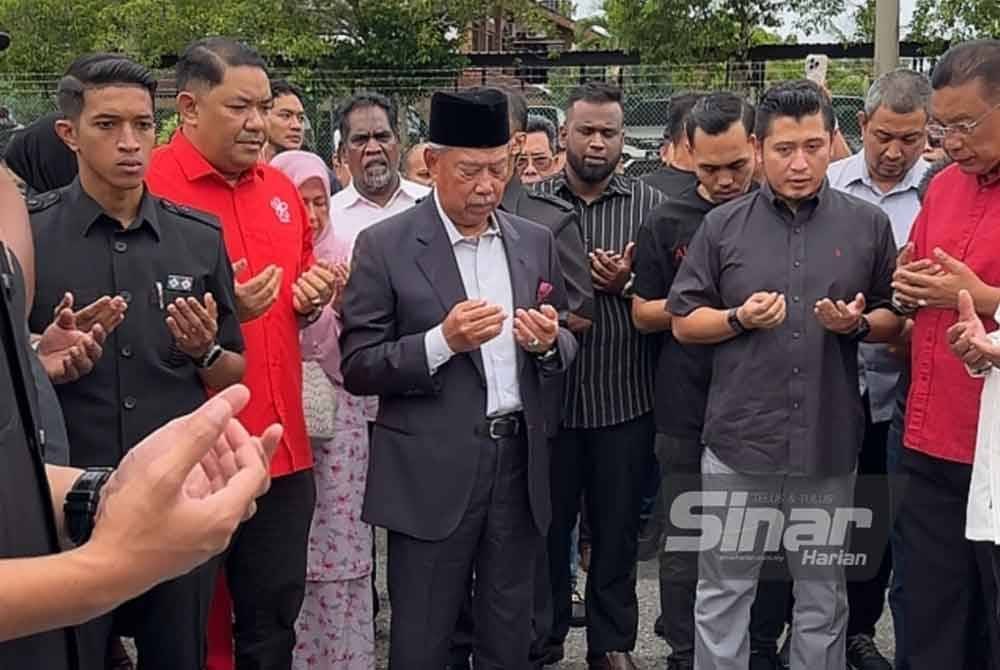 Muhyiddin (tengah) mengaminkan doa bersama penyokong-penyokong di luar pekarangan Mahkamah Gua Musang. Foto Sinar Harian-ADILA SHARINNI WAHID.