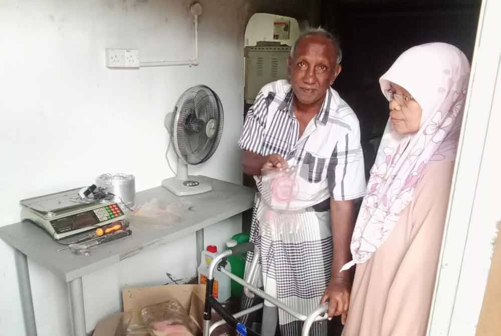 Shamsuddin menunjukkan plastik pembungkusan yang masih elok sambil diperhatikan isterinya Nor Madiah Syarif, 63.