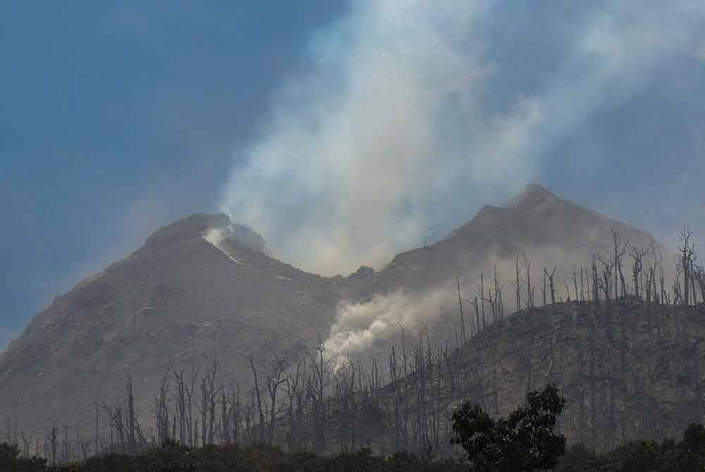 Asap dari Gunung Lewotobi Laki-Laki yang dilihat dari kampung Klatlo, di Kabupaten Flores Timur, Nusa Tenggara Timur. Foto AFP