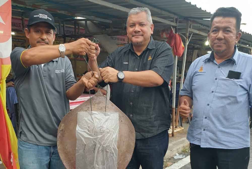 Hasnul (tengah) bergambar bersama hasil tangkapan di Pantai Kelanang, Banting.