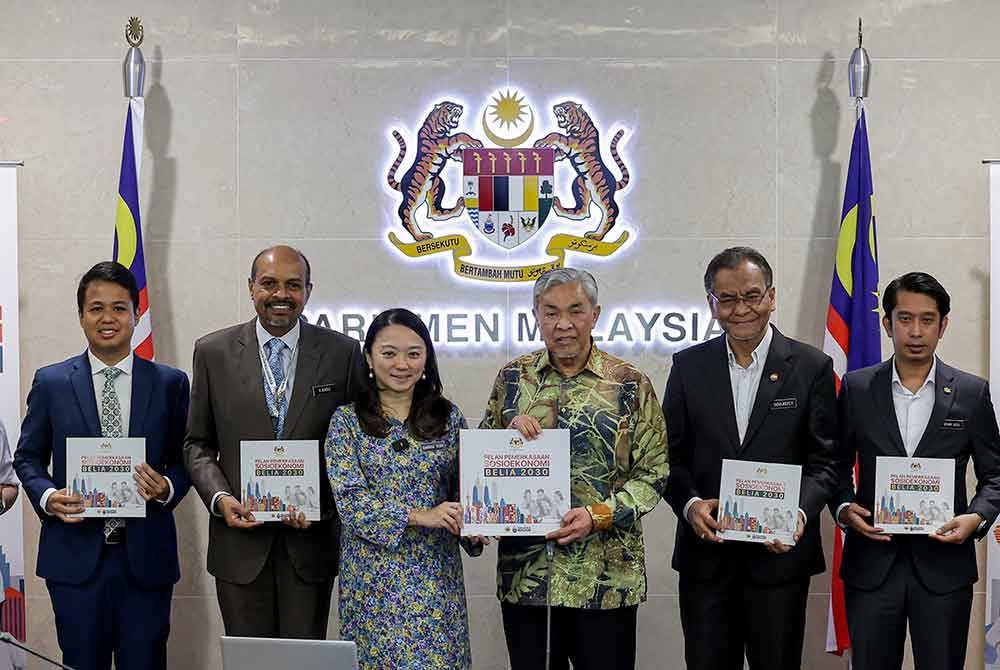 Ahmad Zahid dan Hannah menunjukkan Pelan Pemerkasaan Sosioekonomi Belia 2030 yang dirasmikan Ahmad Zahid di Bilik Mesyuarat Utama, Bangunan Parlimen pada Selasa. Turut sama Adam Adli dan Dr Dzulkefly. Foto Bernama