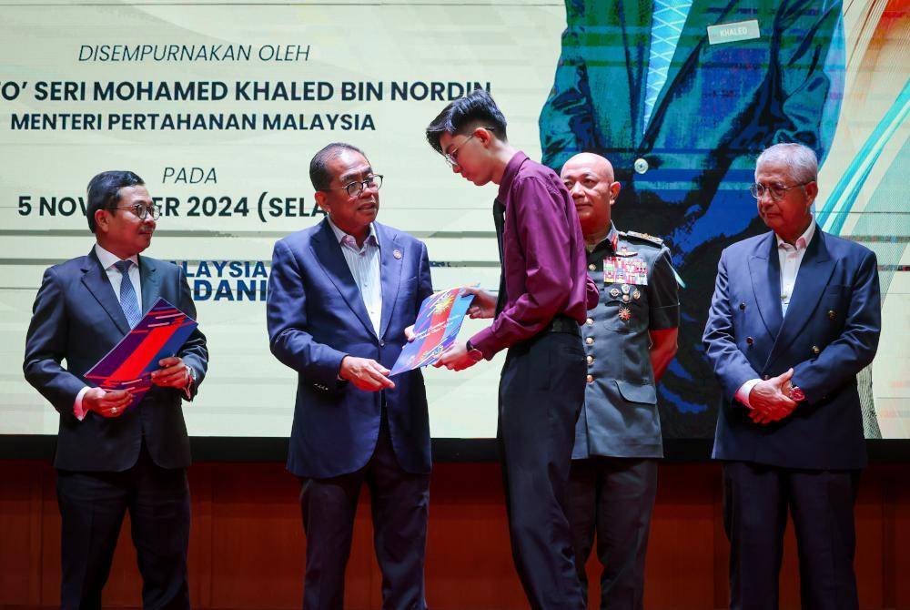 Mohamed Khaled (dua dari kiri) menyerahkan sijil penghargaan kepada anak warga ATM yang cemerlang pada Majlis Penyampaian Anugerah Kecemerlangan Pendidikan Angkatan Tentera Malaysia ke - 34 di Wisma Pertahanan, pada Selasa. Foto Bernama