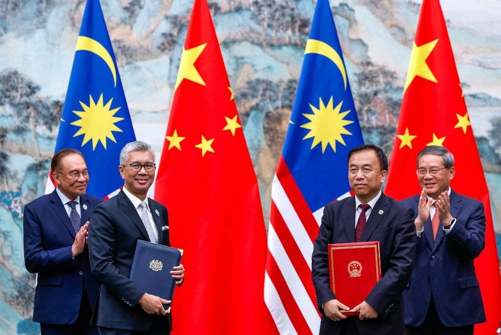 Anwar (kiri) bersama Li Qiang (kanan) menyaksikan pertukaran dokumen antara Tengku Zafrul (dua dari kiri) dan Liu Sushe (dua dari kanan). Foto Bernama