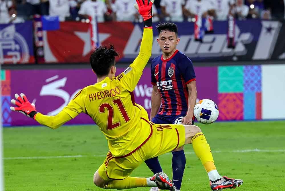 Pemain JDT, Arif Aiman (kanan) melakukan percubaan dan dihalang penjaga gawang Ulsan HD FC Jo Hyeonwoo (kiri) pada perlawanan Liga Juara-Juara Asia (ACL) Elite di Stadium Sultan Ibrahim, pada Selasa. Foto Bernama