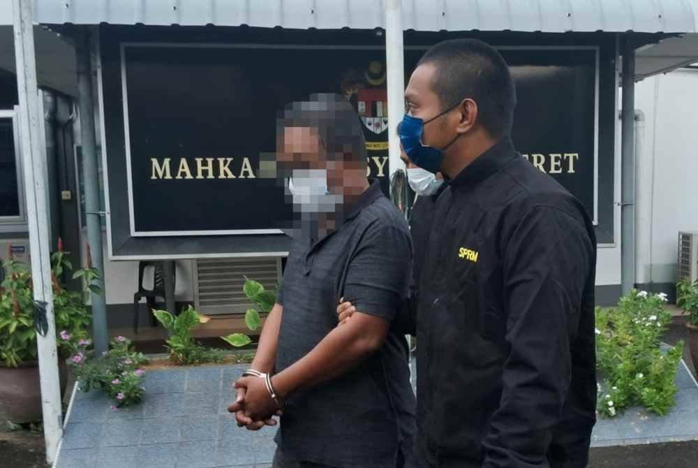 Suspek (kiri) dibawa ke Mahkamah Majistret Kemaman oleh anggota SPRM pada Rabu bagi mendapatkan perintah reman.