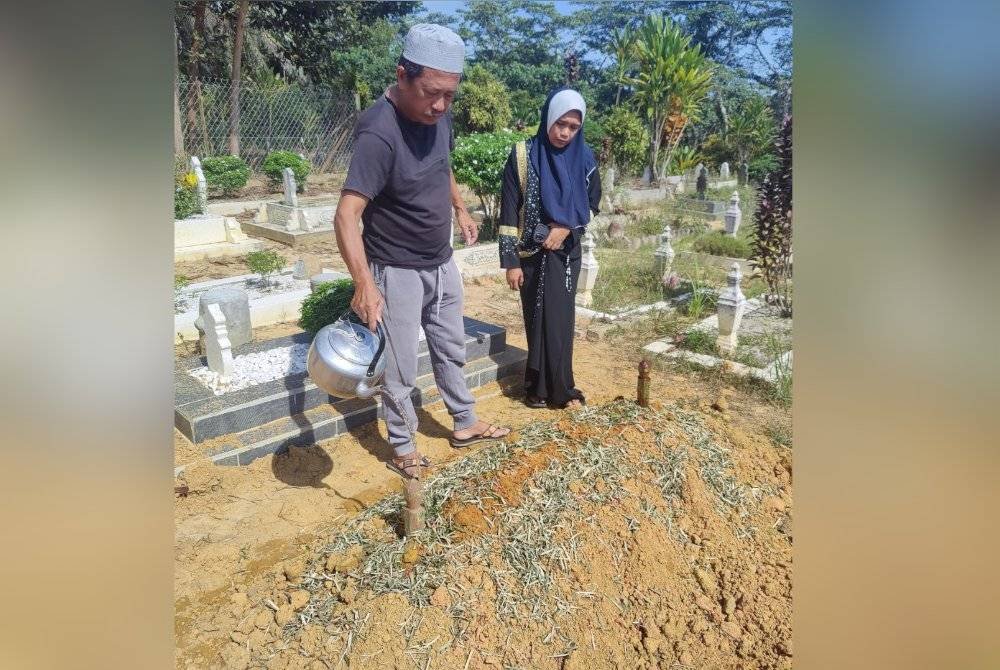 Emilia ditemani suami menyiram pusara Allahyarham Muhammad Adib yang dikebumikan di Tanah Perkuburan Islam Kampung Gesir Tengah pada Khamis.