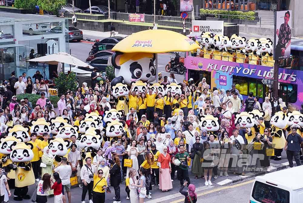 Orang ramai bergambar bersama pasukan maskot PANDAi di Bukit Bintang sempena Majlis Pelancaran MR D.I.Y. PANDAi Jaga Anda pada Khamis. FOTO: SINAR HARIAN / MOHD HALIM ABDUL WAHID