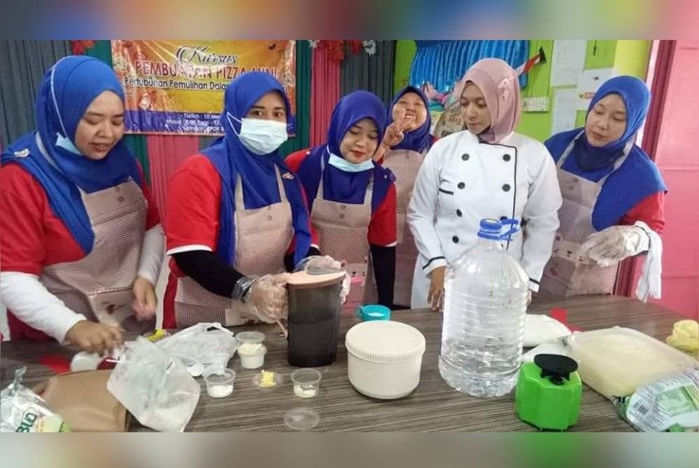 Noor Azlina (dua kanan) ketika menjadi tenaga pengajar pembuatan roti di Bahau.