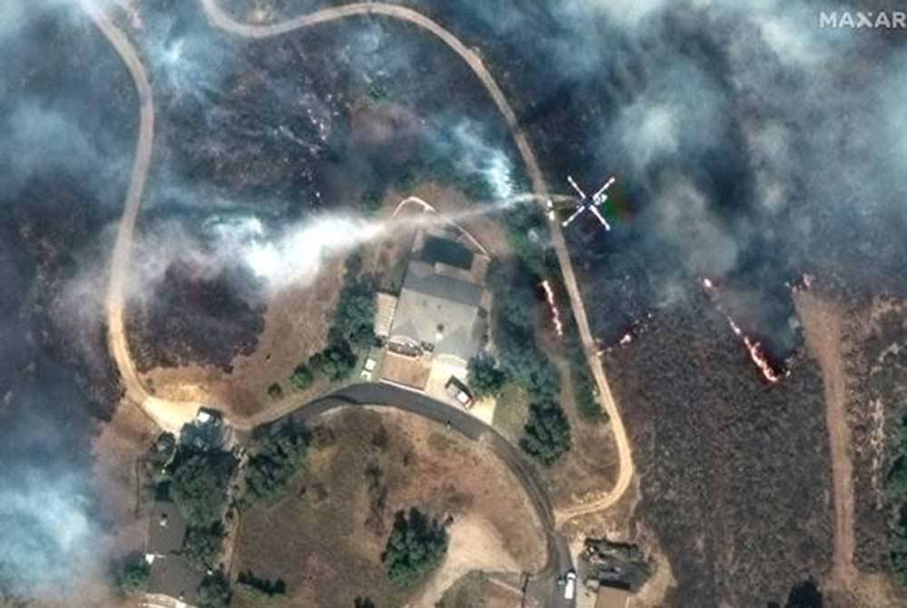 Imej satelit menunjukkan helikopter pemadam kebakaran berlegar di udara, susulan kebakaran hutan di kawasan gunung di Moorpark, California, AS. Foto Maxar Technologies/Handout via REUTERS