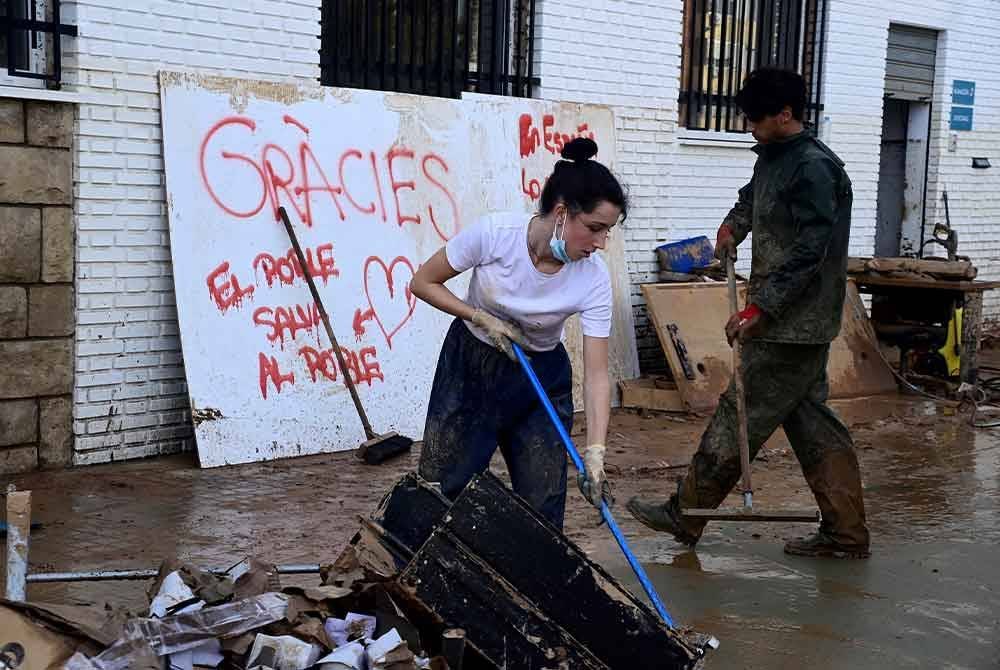 Orang ramai mula membersihkan kediaman masing-masing yang dilitupi lumpur di Sedavi, selatan Valencia.