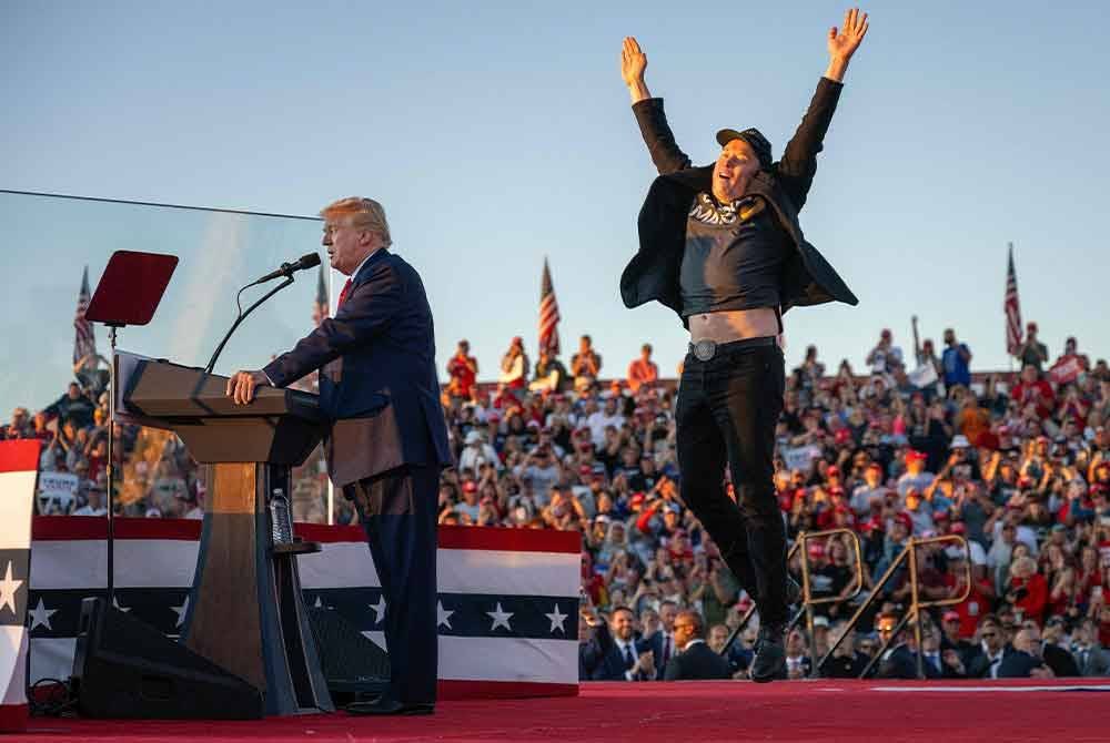 Musk (kanan) melompat di atas pentas ketika menyertai kempen Trump di Butler, Pennsylvania pada 5 Oktober. Foto AFP