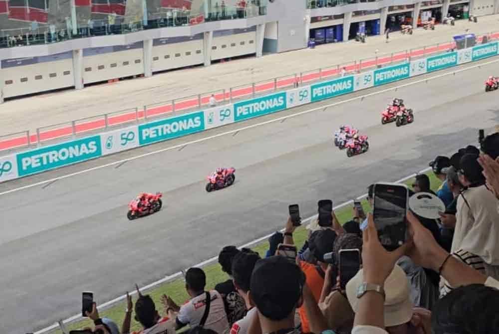 Orang ramai tidak melepaskan peluang untuk merakam aksi pelumba MotoGP ketika berada di grandstan SIC.