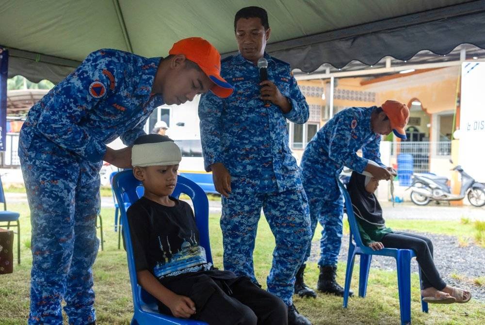 Pegawai Operasi dan Bencana APM Kelantan, Kapt (PA) Mohd Fadir Md Nor menerangkan kepada penduduk kampung langkah keselamatan bagi menghadapi musim banjir. Foto Bernama