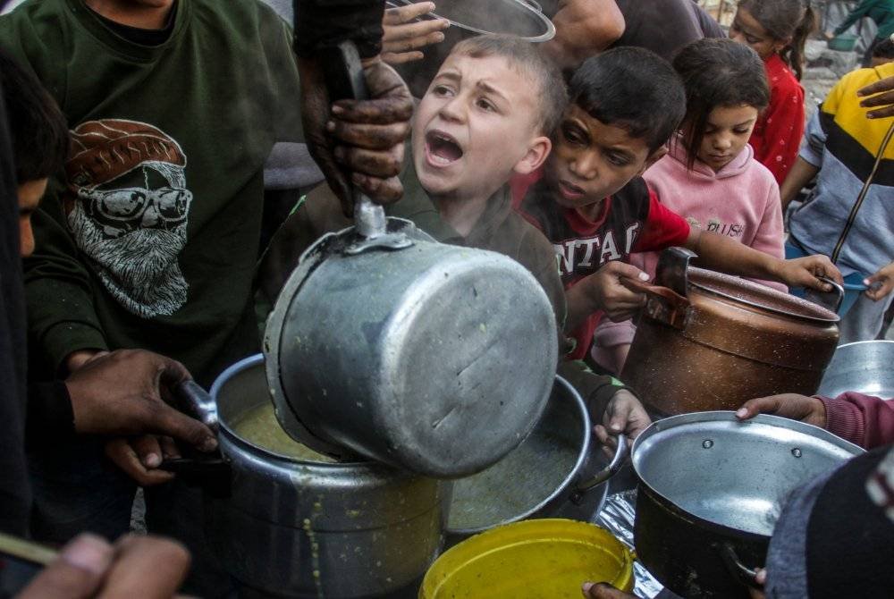 Orang ramai menerima bantuan makanan di Kota Gaza. Seluruh penduduk Palestin di Gaza Utara menghadapi risiko kematian akibat penyakit, kebuluran dan keganasan. Foto Xinhua