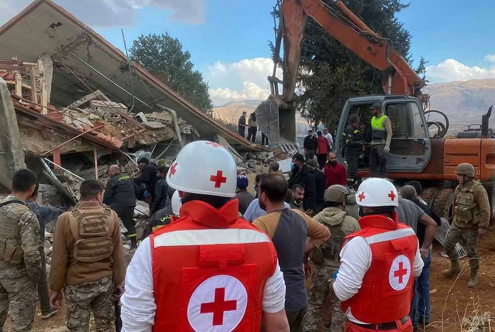 Pasukan penyelamat dari Lebanese Red Cross and askar berkumpul di lokasi serangan udara Israel di Rasm El-Hadath Lubnan pada Ahad. Foto AFP