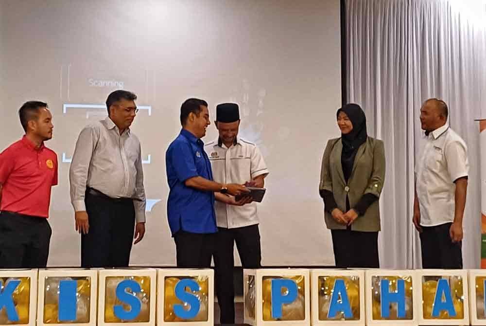 Sharudin (tiga kiri) menyaksikan gimik perasmian yang dilakukan Yusof pada majlis penyampaian hadiah pertandingan kitar semula sekolah rendah dan menengah peringkat Pahang di sini pada Selasa.