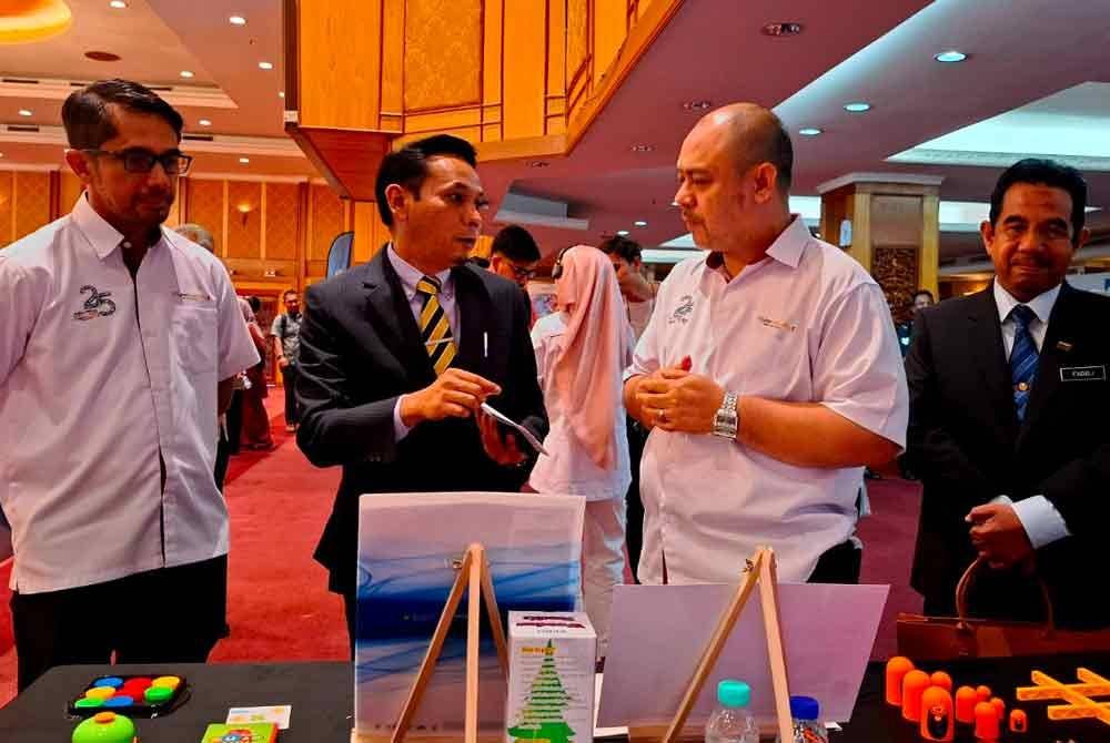 Wan Roshaimi (kiri) bersama Mohd Azlan (dua dari kiri) meninjau ruang pameran yang disediakan sempena Jelajah Anti-Scam Kebangsaan (JASK) 2024 peringkat negeri Perak pada Selasa.