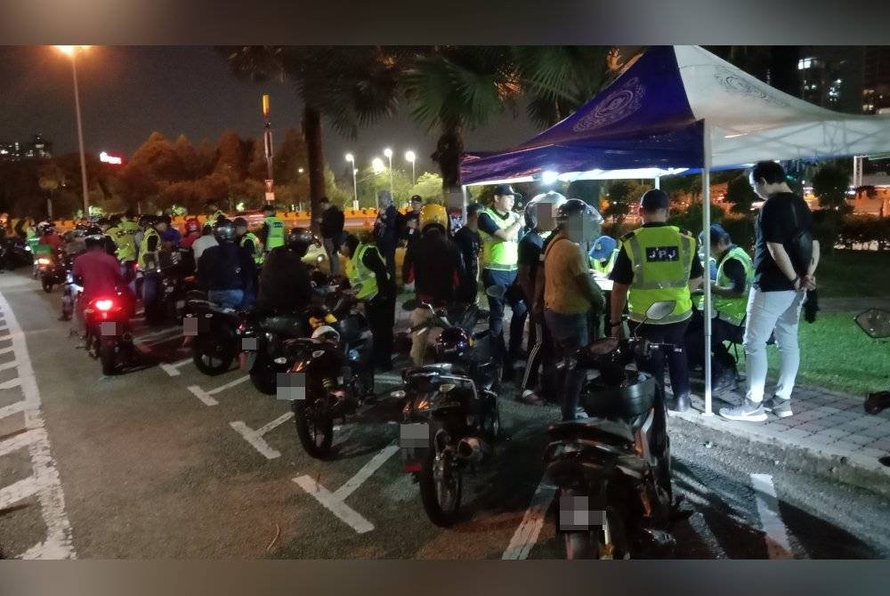 Antara penunggang motosikal yang diperiksa menerusi operasi di Plaza Tol Petaling Jaya, Lebuhraya Damansara- Puchong di sini pada Selasa.