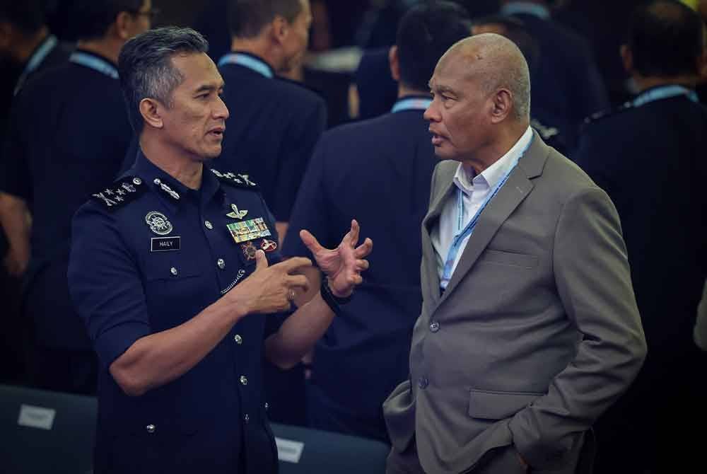 Shuhaily (kiri) beramah mesra bersama bekas Ketua Polis Negara, Tan Sri Musa Hasaan pada Penutup Seminar Penguatkuasaan Atipsom di Banda Hilir, hari ini. - Foto: Bernama