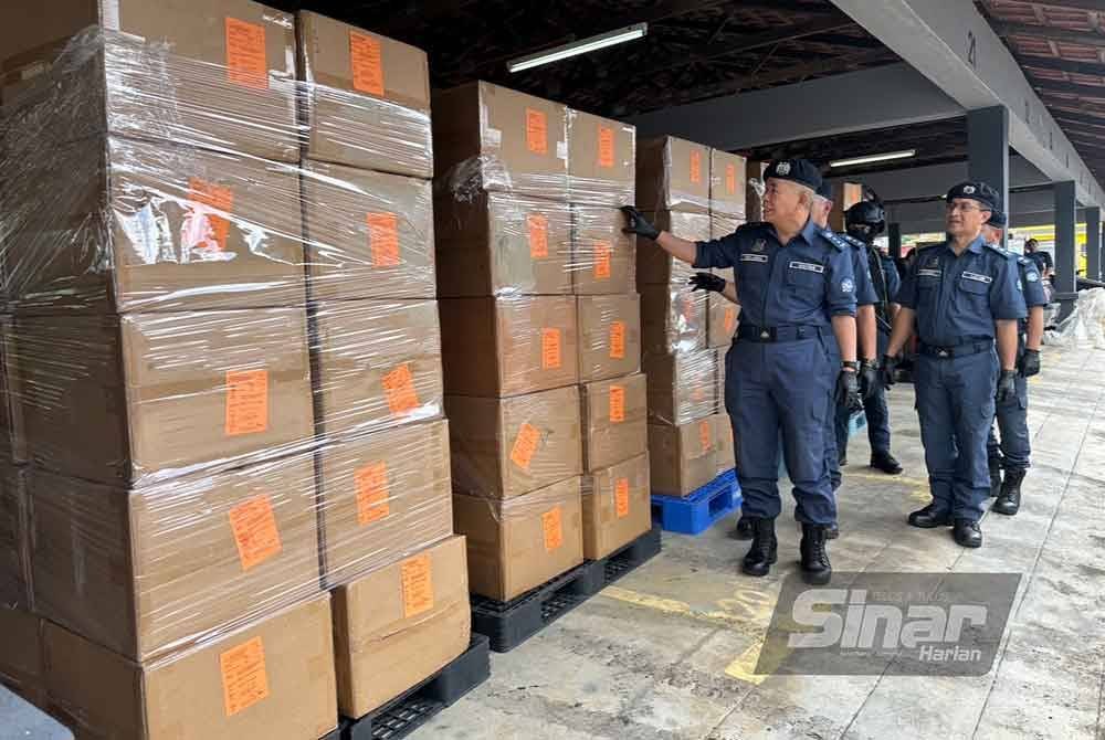 Wan Jamal Abdul Salam (kiri) menunjukkan kotak-kotak mengandungi rokok-rokok yang dibawa keluar dari kontena. FOTO SINAR HARIAN-ADILA SHARINNI WAHID.