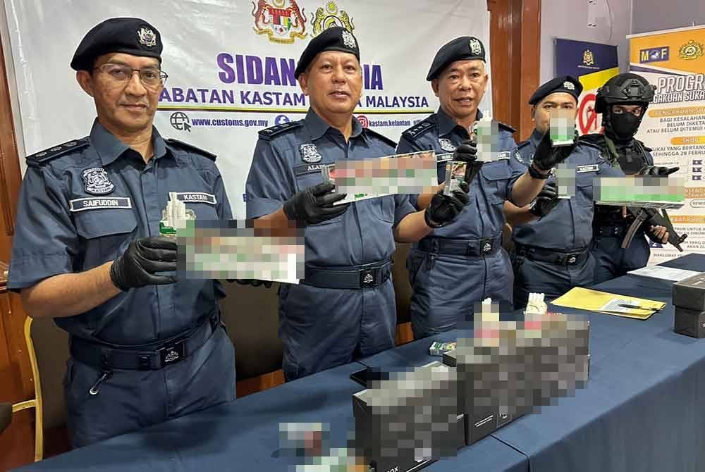 Wan Jamal (tengah) menunjukkan rokok dengan setem cukai palsu. FOTO SINAR HARIAN-ADILA SHARINNI WAHID.