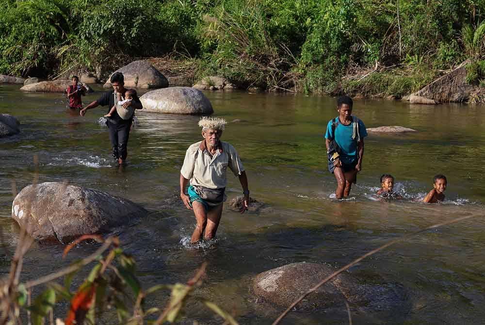 Sekumpulan penduduk Orang Asli suku Temiar terpaksa menyeberangi Sungai Puian untuk ke Kampung Gob. Foto Bernama