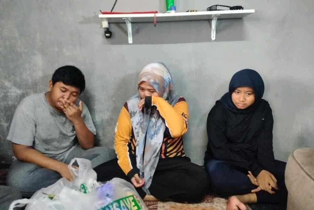 Norzainizah (tengah) tidak dapat menahan kesedihan mengenangkan nasib dua orang anaknya yang masih bersekolah.