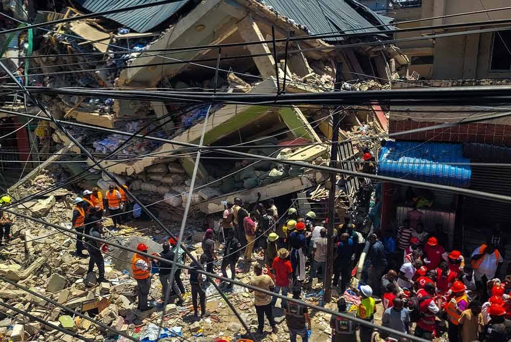 Pasukan penyelamat mencari mangsa yang terperangkap dalam bangunan runtuh di pinggir bandar Kariakoo Dar es Salaam, Tanzania. Foto Xinhua